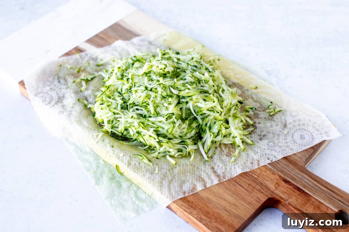 Moist Zucchini Chocolate Chip Muffins Recipe 3 Finely grated zucchini on wooden chopping board