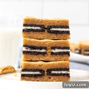 Stack of three peanut butter Oreo blondies with glass of milk