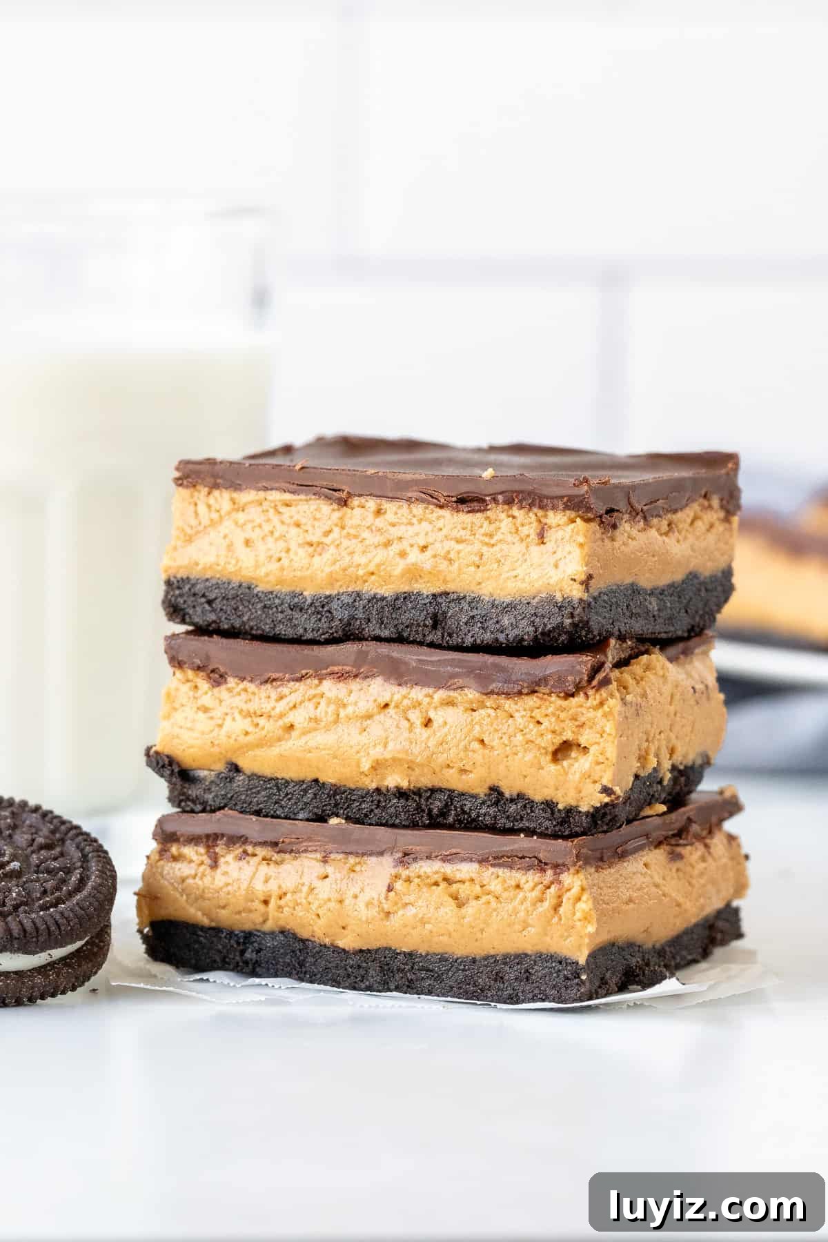 Oreo Peanut Butter Bars Recipe — No-Bake Dessert Squares 2 Three peanut butter Oreo bars, stacked one on top of another.