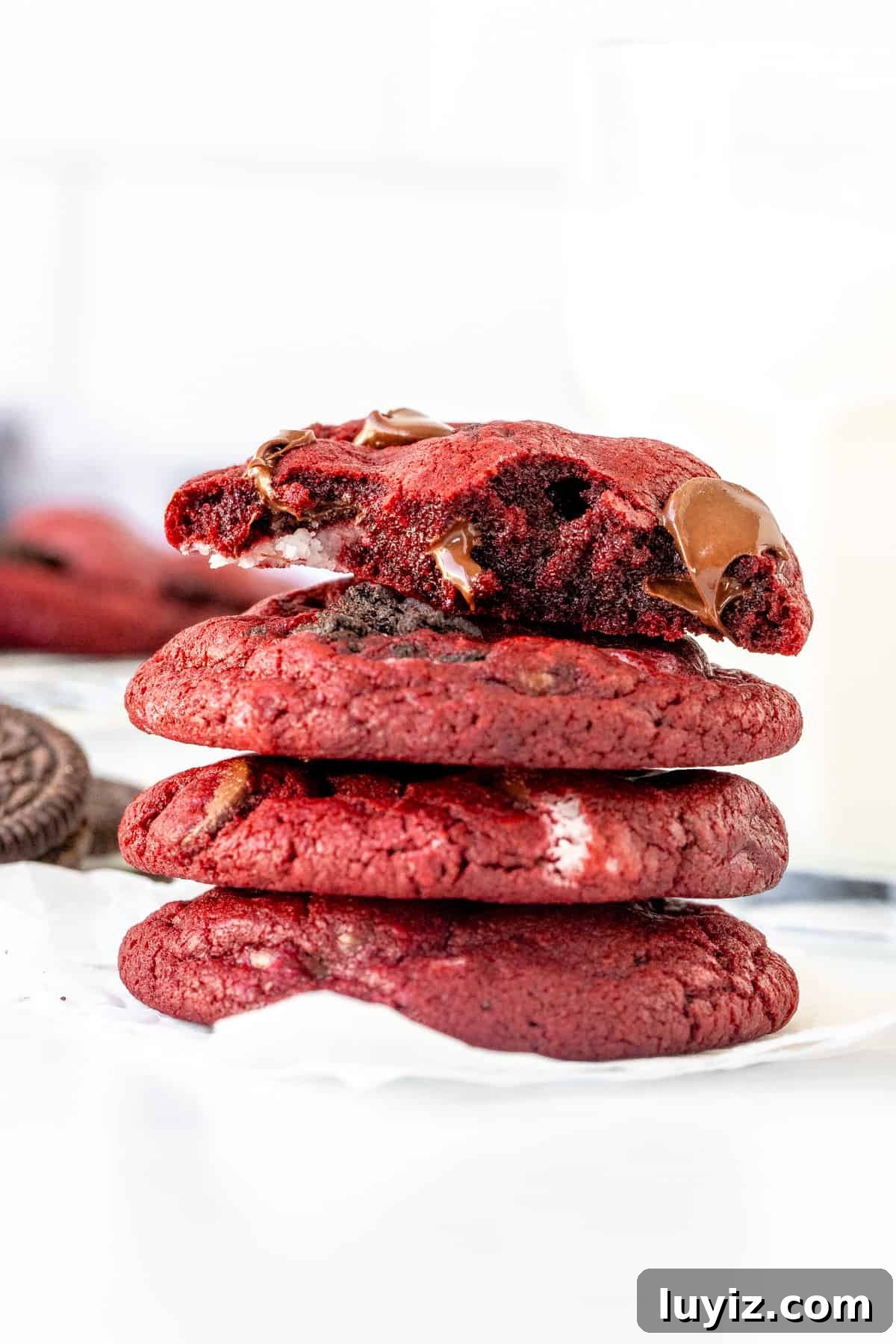 Oreo Red Velvet Cookie Recipe: Cream Cheese Frosting Twist 7 Stack or Oreo red velvet cookies, with top cookie broken in half.