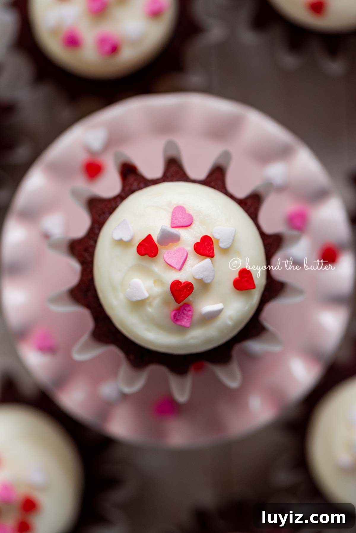 Perfect Red Velvet Cupcakes Recipe for Moist, Fluffy Results 11 Homemade red velvet cupcakes with cream cheese frosting topped with heart sprinkles on a a small pink cupcake stand | All images © Beyond the Butter®