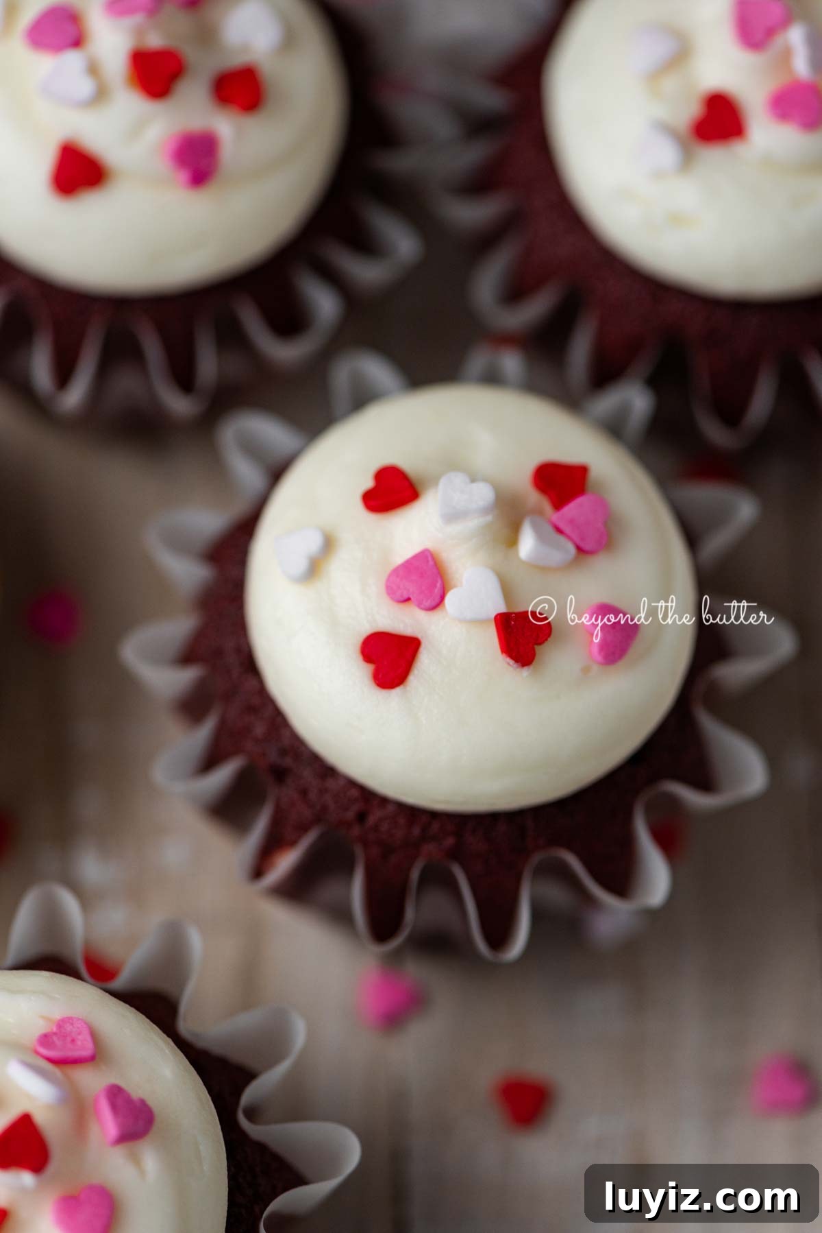 Perfect Red Velvet Cupcakes Recipe for Moist, Fluffy Results 10 Homemade red velvet cupcakes with cream cheese frosting topped with heart sprinkles on a light wood background | All images © Beyond the Butter®