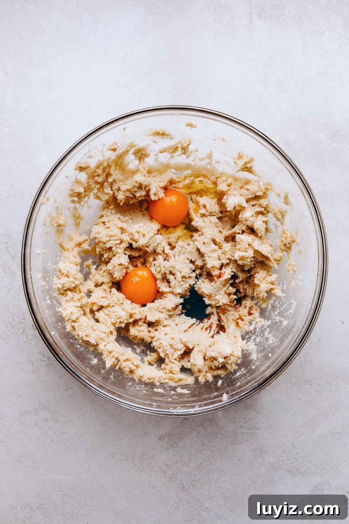 Salted Caramel Oatmeal Chocolate Chip Cookies 6 Wet ingredients blended together in a glass mixing bowl with egg yolks and vanilla extract on top.