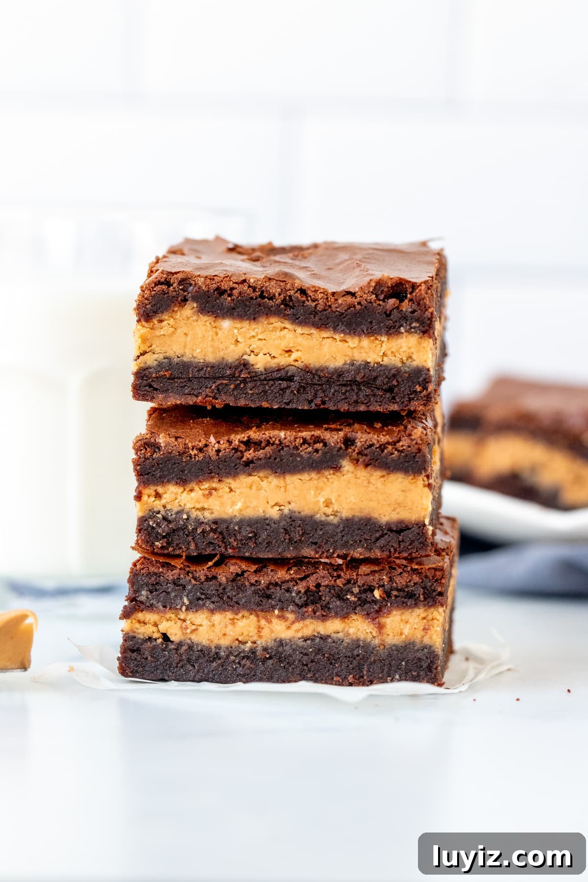 Decadent Peanut Butter-Stuffed Brownies Recipe 2 Stack of 3 peanut butter stuffed brownies with glass of milk