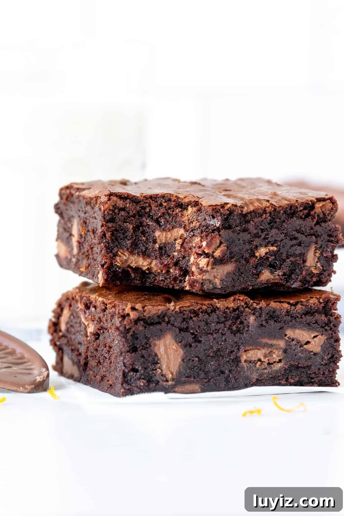 Decadent Chocolate Orange Brownies with Zesty Citrus Glaze 8 Two chocolate orange brownies on top of each other, with bite taken out of the top brownie