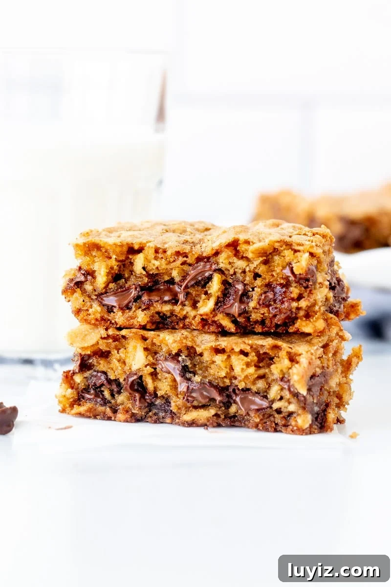 Chewy Oatmeal Chocolate Chip Cookie Bars Recipe 3 Oatmeal chocolate chip cookie bar broken in half with glass of milk