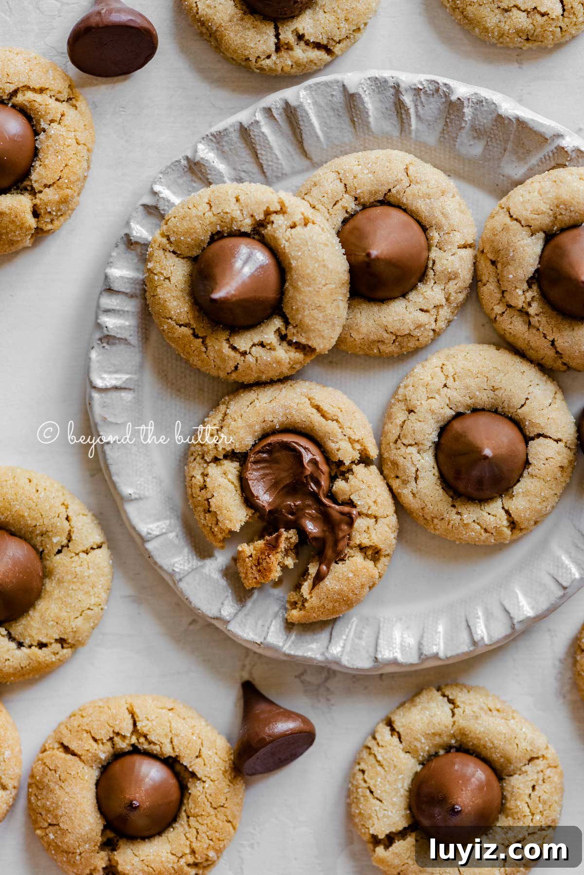 Classic Peanut Butter Blossom Cookies Recipe 6 Small dessert plate full of classic peanut butter blossoms with one melted and split apart