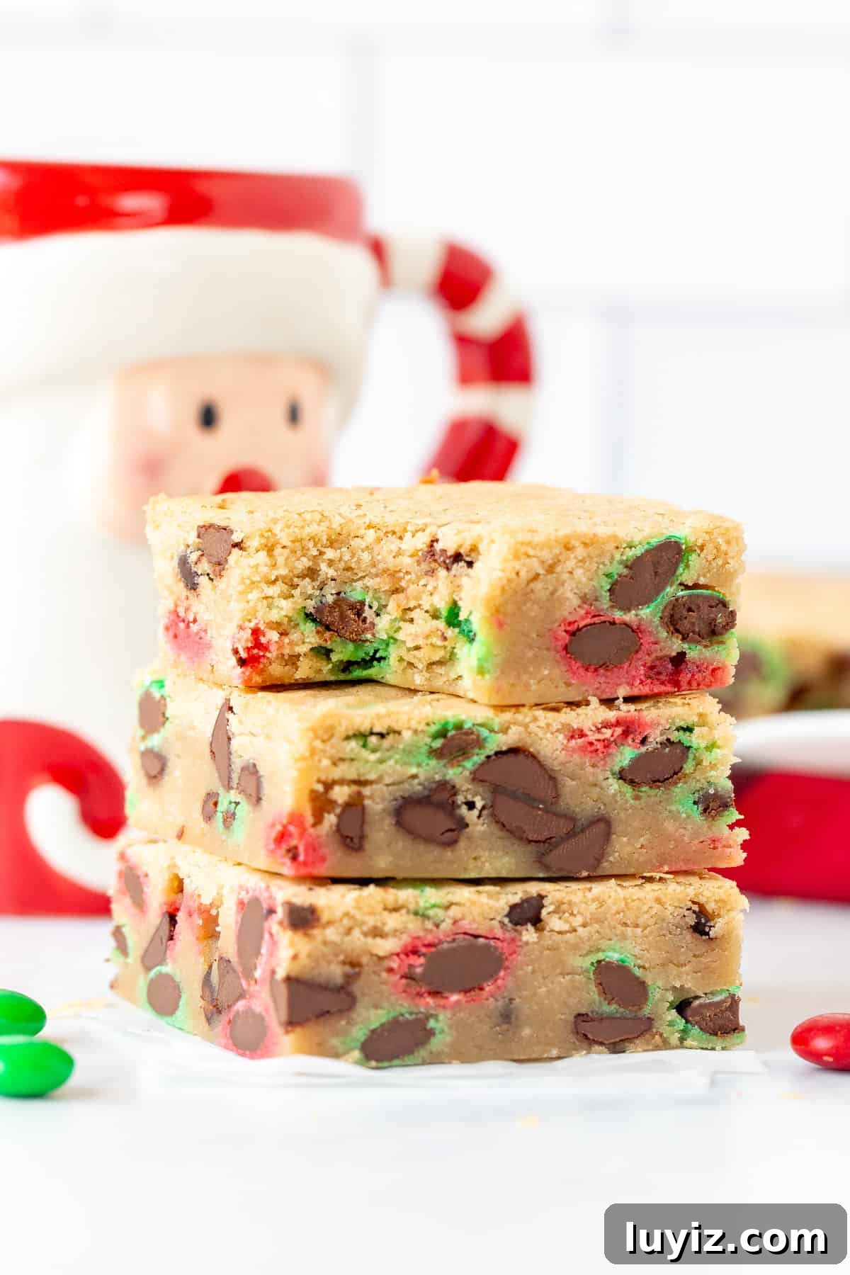 Christmas M&M Cookie Bars Recipe — Festive Holiday Treat 7 Three M&M cookie bars, one on top of each other with a bite out of the top bar