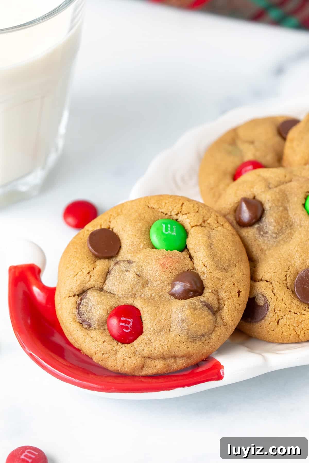 Christmas Peanut Butter M&M Cookies: Festive Holiday Recipe 7 Christmas M&M peanut butter cookies on a Santa plate with a glass of milk