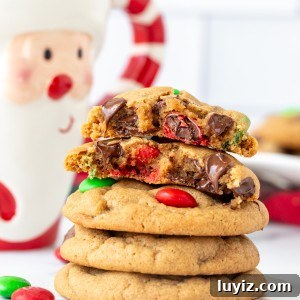 Stack of Christmas M&M peanut butter cookies, with top cookie broken in half