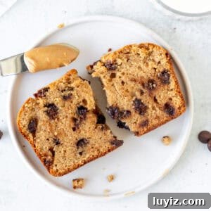 Slice of peanut butter bread broken in half with glass of milk