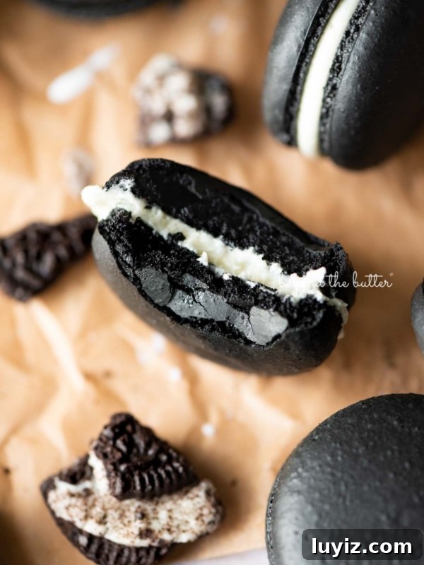 Decadent Chocolate Ricotta Cake Recipe for Moist, Fluffy Results 15 Half eaten oreo macaron on parchment paper surrounded by oreo macarons and broken pieces of oreo cookies.