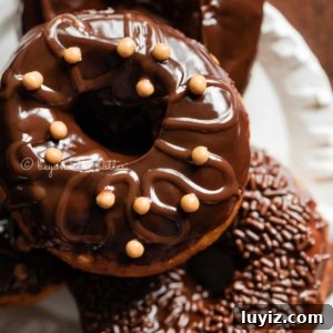 Homemade Donuts from Scratch: Classic Recipe for Soft, Fluffy Donuts 14 Easy homemade donuts from scratch topped with chocolate glaze stacked on a dessert plate.