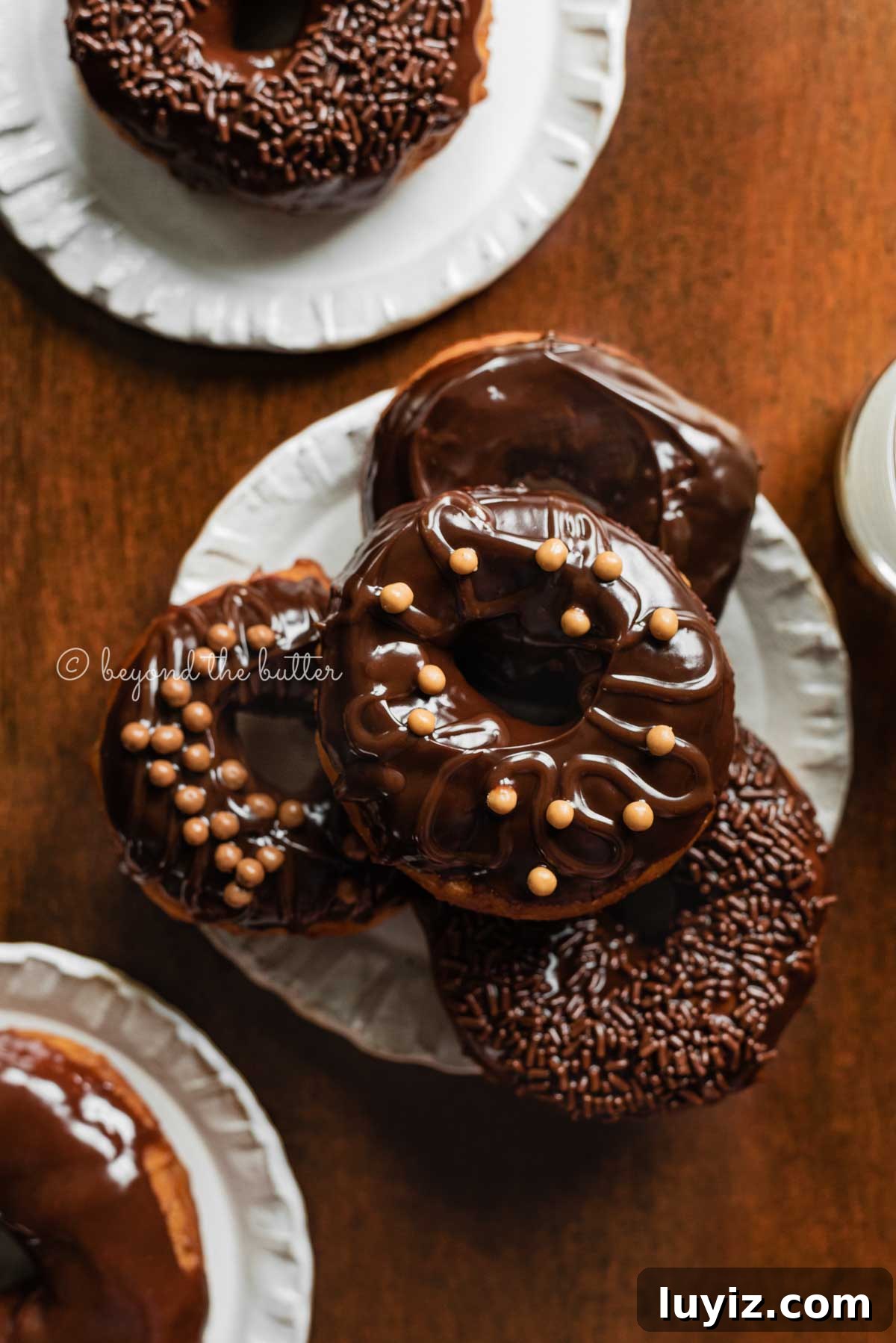 Homemade Donuts from Scratch: Classic Recipe for Soft, Fluffy Donuts 15 Easy homemade donuts from scratch topped with chocolate glaze stacked on a dessert plate | All Images © Beyond the Butter™