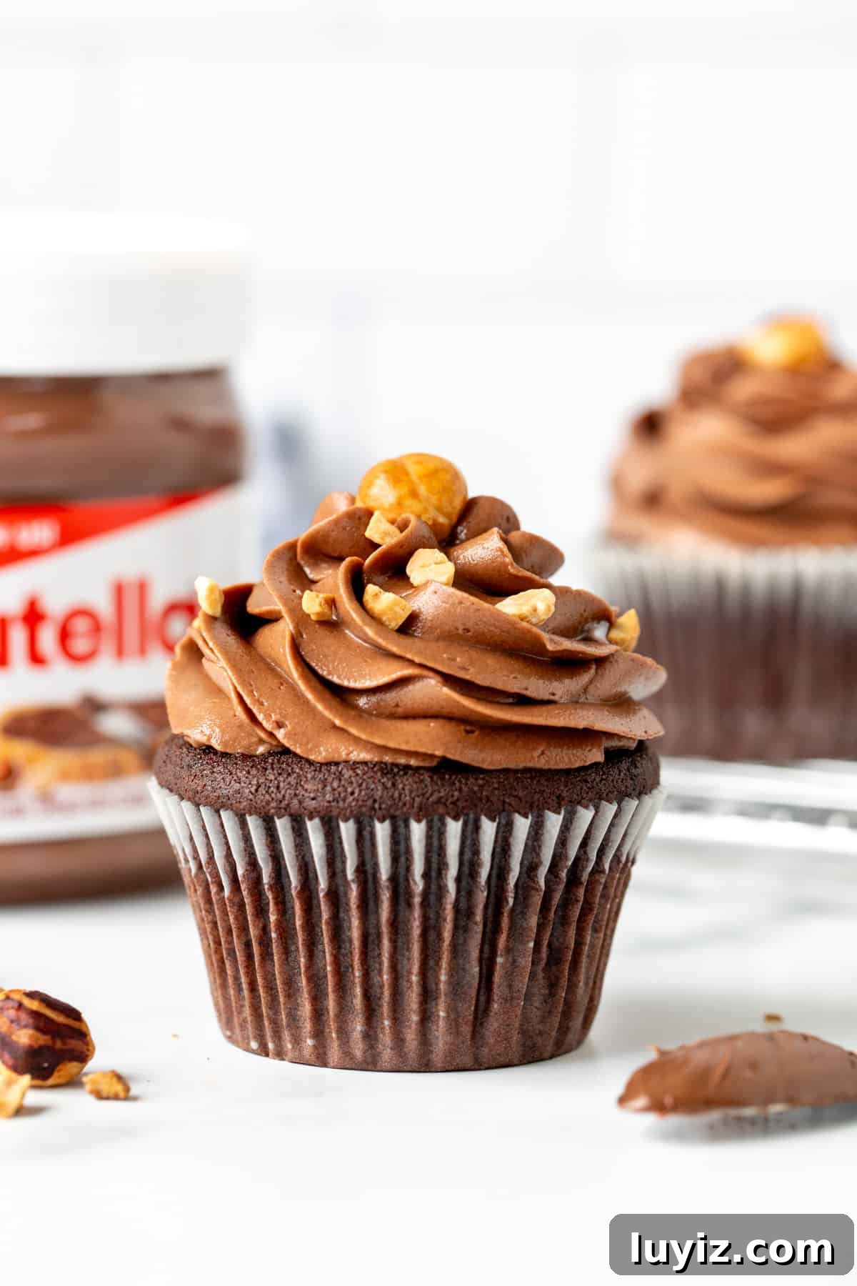 Decadent Nutella Cupcakes Recipe with Chocolate Hazelnut Swirl 2 Nutella cupcake with Nutella frosting and jar of Nutella