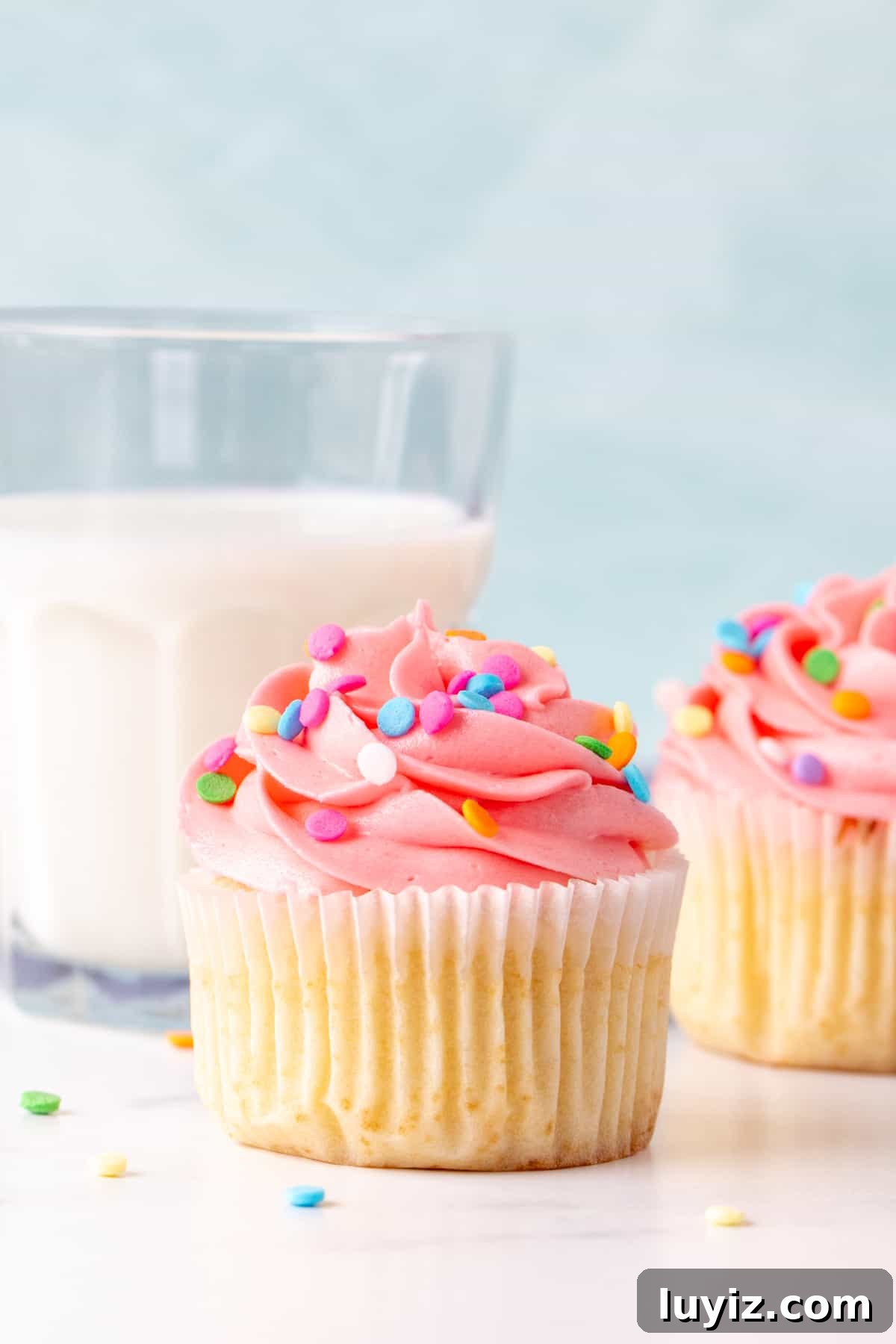 Perfect Vanilla Cupcakes for Two: Simple Small-Batch Recipe 6 Two vanilla cupcakes with pink frosting with a glass of milk