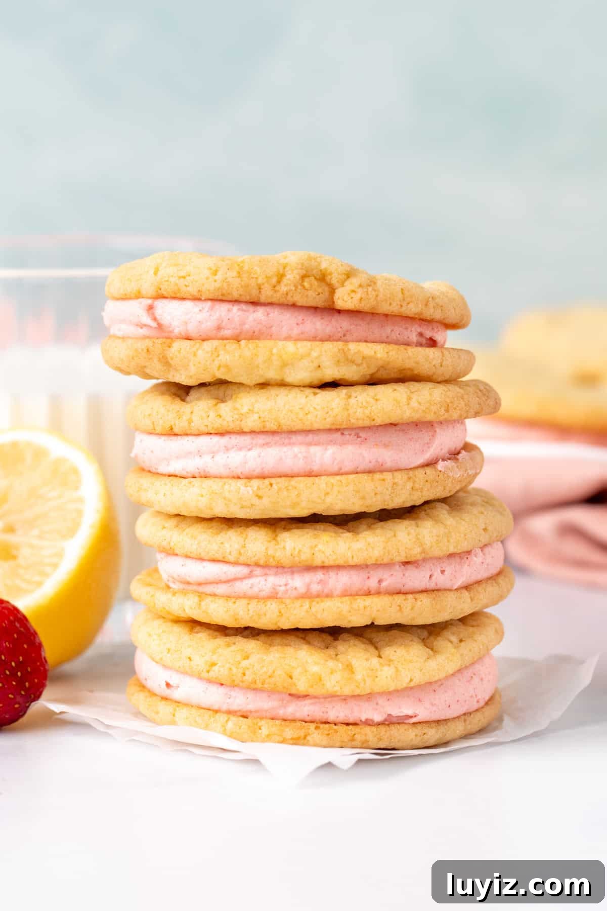 Lemon Sandwich Cookies with Strawberry Buttercream Filling 3 Stack of 4 lemon sandwich cookies with pink strawberry frosting