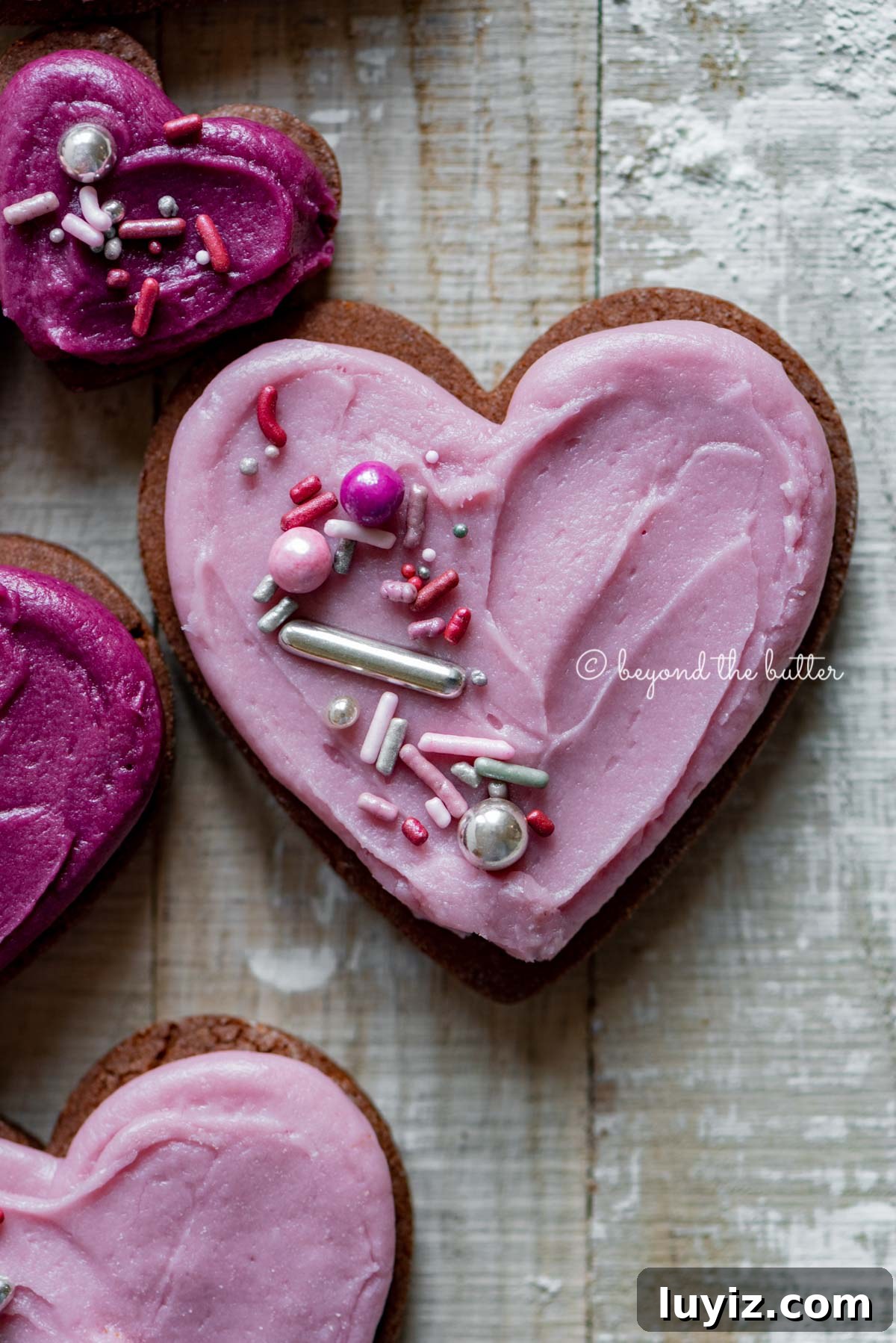 Chocolate Cut-Out Cookies: Classic Cocoa Sugar Cookie Recipe 4 Closeup of decorated chocolate cut out sugar cookies on a light wood colored background | All Images © Beyond the Butter®