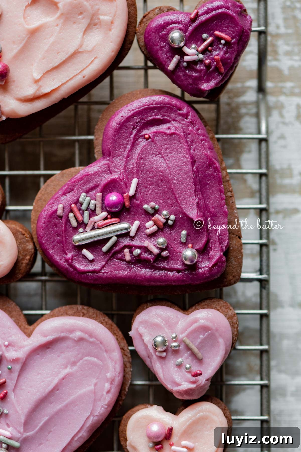Chocolate Cut-Out Cookies: Classic Cocoa Sugar Cookie Recipe 5 Closeup of decorated chocolate cut out sugar cookies on a wire cooling rack on light wood colored background | All Images © Beyond the Butter®