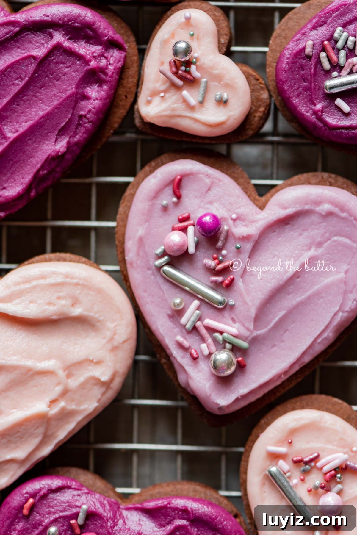 Chocolate Cut-Out Cookies: Classic Cocoa Sugar Cookie Recipe 6 Closeup of decorated chocolate cut out sugar cookies on a wire cooling rack on light wood colored background | All Images © Beyond the Butter®