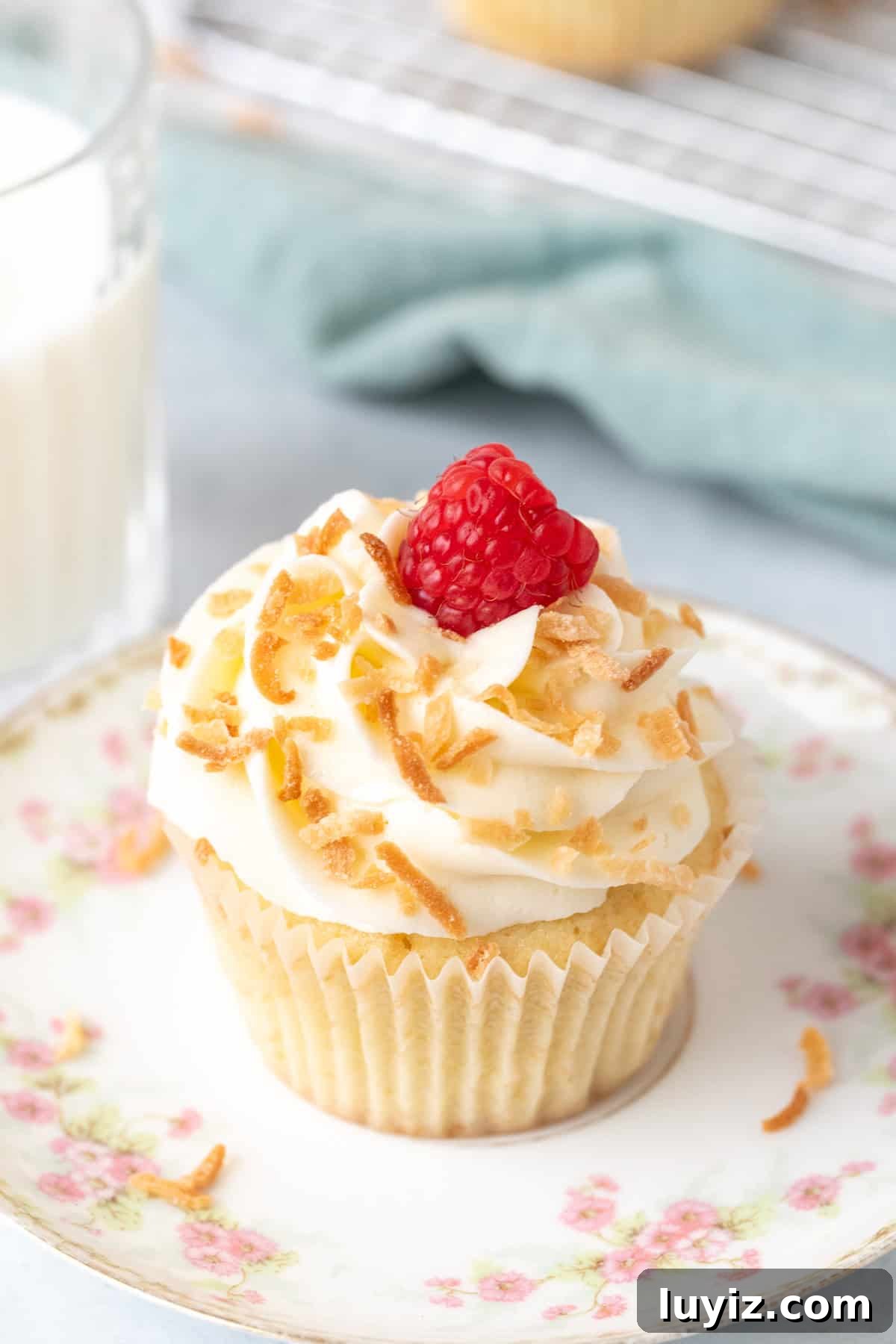 Coconut Cupcakes Recipe: Moist, Tropical Frosted Treats 6 Coconut cupcake on a plate with glass of milk
