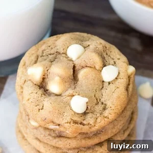 Peanut Butter White Chocolate Chip Cookies Recipe for Chewy Cookies 7 Overhead shot of a stack of peanut butter white chocolate chip cookies. Glass of milk and bowl of peanut butter in the background