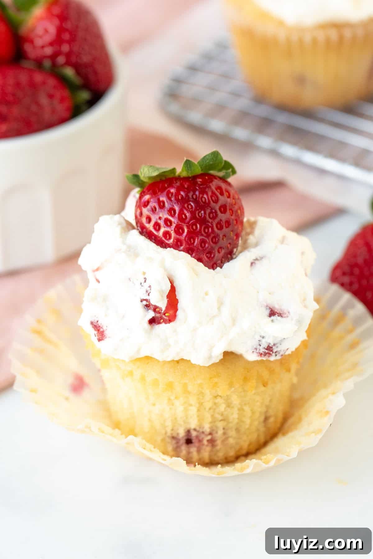 Strawberry Cream Cupcakes Recipe: Light, Fresh & Frosted 2 Strawberries and cream cupcake with muffin paper removed with bowl of strawberries