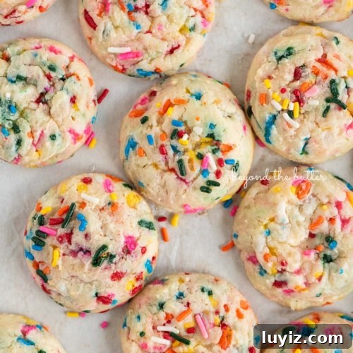 15 Delightful Easter Desserts to Impress Your Guests 14 Funfetti butter cookies topped with sparkling sugar placed randomly on a white sheet of parchment paper.