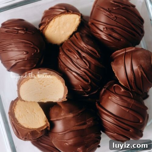 15 Delightful Easter Desserts to Impress Your Guests 5 Chilled chocolate covered peanut butter eggs drizzled with more chocolate randomly placed in a glass container with two cut in half on white background.