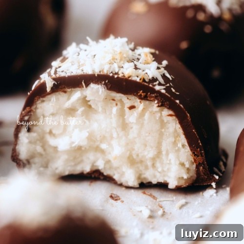 15 Delightful Easter Desserts to Impress Your Guests 8 Chocolate dipped coconut buttercream eggs with center egg sliced in half to see the inside creamy texture on white background.