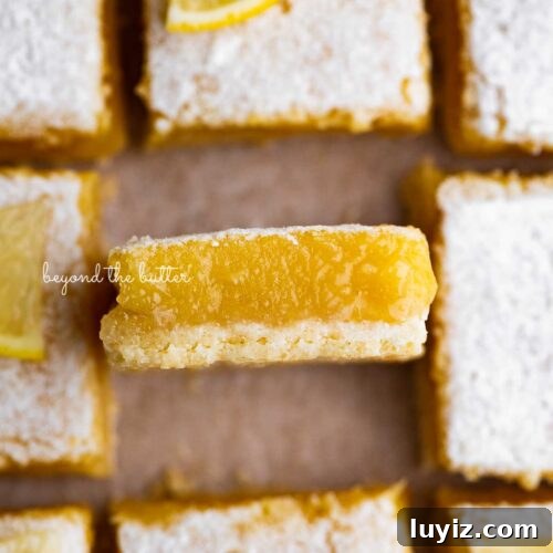 15 Delightful Easter Desserts to Impress Your Guests 10 Sliced super easy lemon bars on parchment paper with the center lemon bar on its side.
