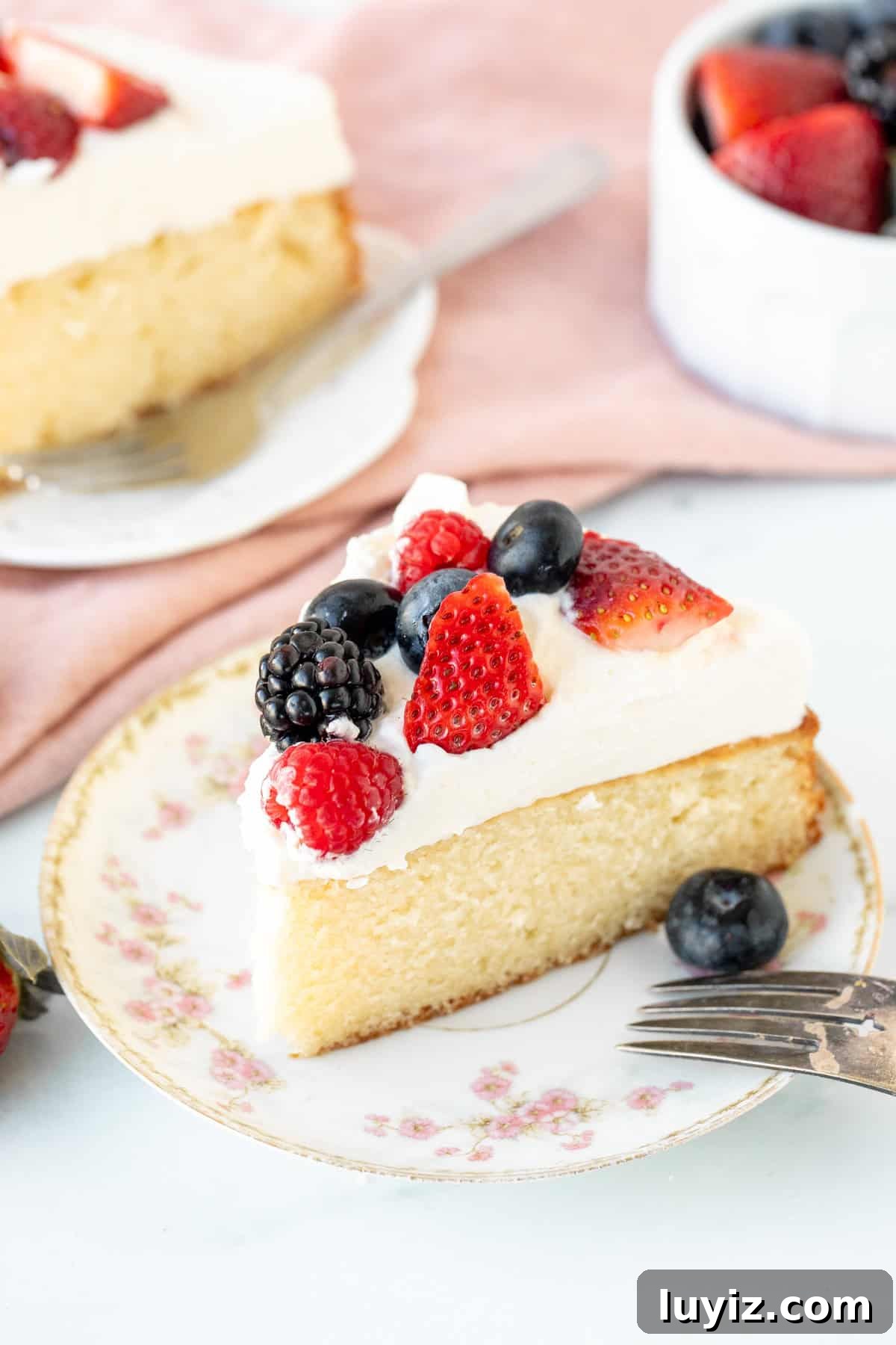 Decadent Berries and Cream Layer Cake Recipe 3 Slice of cake topped with whipped cream and berries