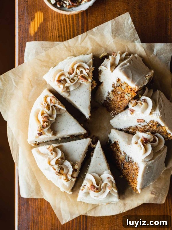 Light and Airy Chocolate Chiffon Cake Recipe 13 Overhead image of single layer carrot cake frosted on parchment paper and placed on a wood dining room table.