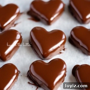 Chocolate-Covered Peanut Butter Heart Truffles 13 Rows of just dipped chocolate covered peanut butter hearts on a wax paper lined baking sheets.