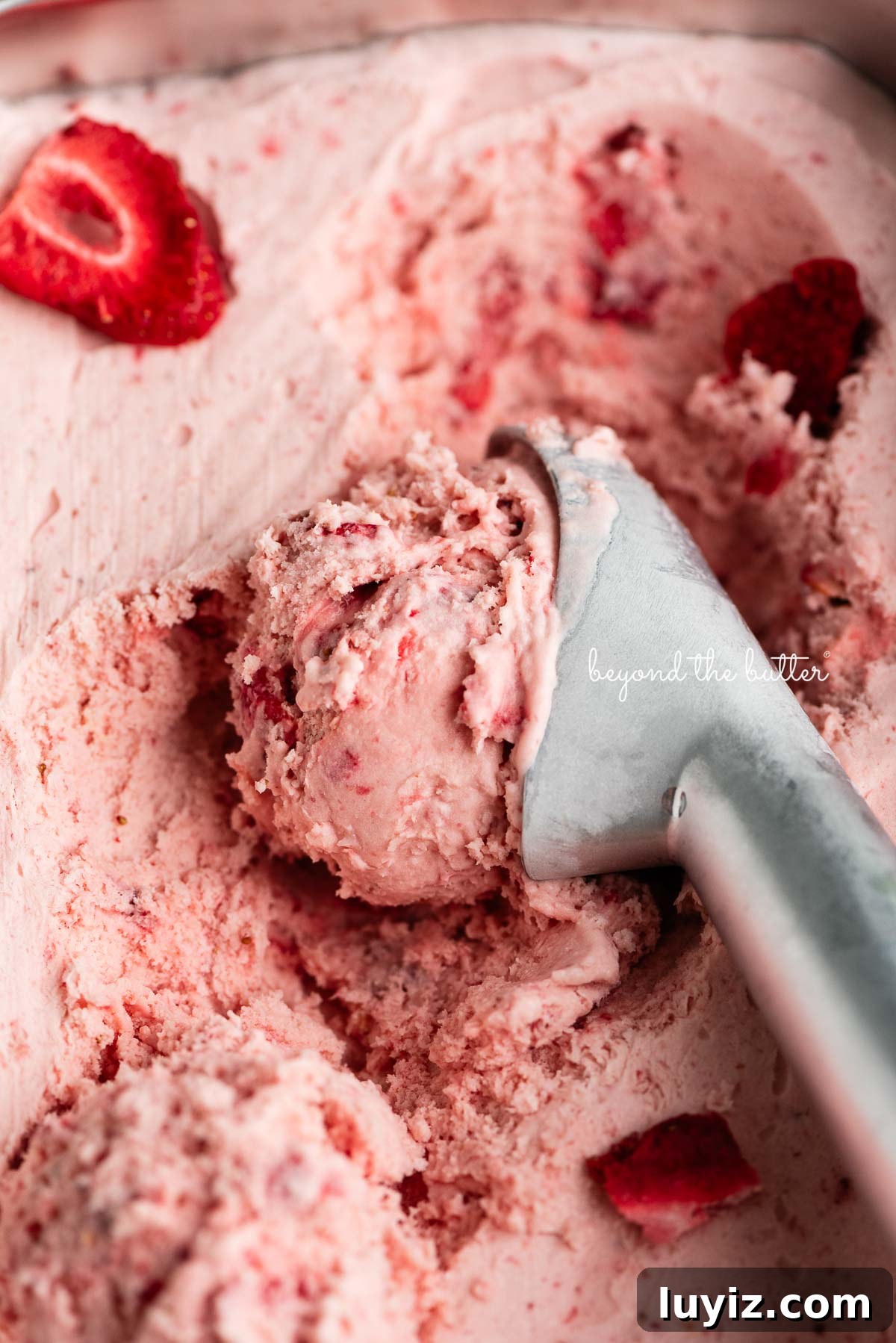 Creamy Homemade Strawberry Ice Cream Recipe You’ll Love 2 Container of strawberry ice cream with a scoop taken out using a stainless steel ice cream scoop.