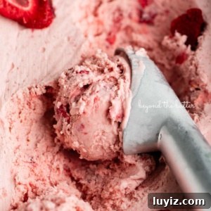 Creamy Homemade Strawberry Ice Cream Recipe You’ll Love 16 Container of strawberry ice cream with a scoop taken out using a stainless steel ice cream scoop.