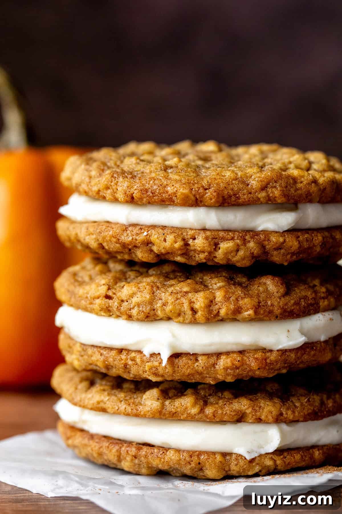 Pumpkin Oatmeal Cream Pies Recipe — Cozy Fall Dessert 2 Three pumpkin oatmeal cream pie cookies, stacked on top of each other