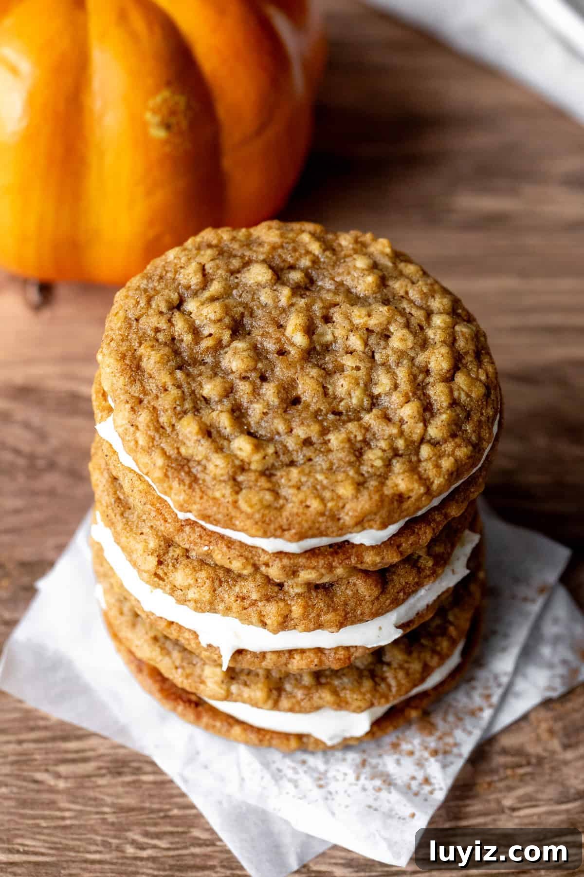 Pumpkin Oatmeal Cream Pies Recipe — Cozy Fall Dessert 3 Stack of three pumpkin cookies sandwiched together with cream cheese frosting