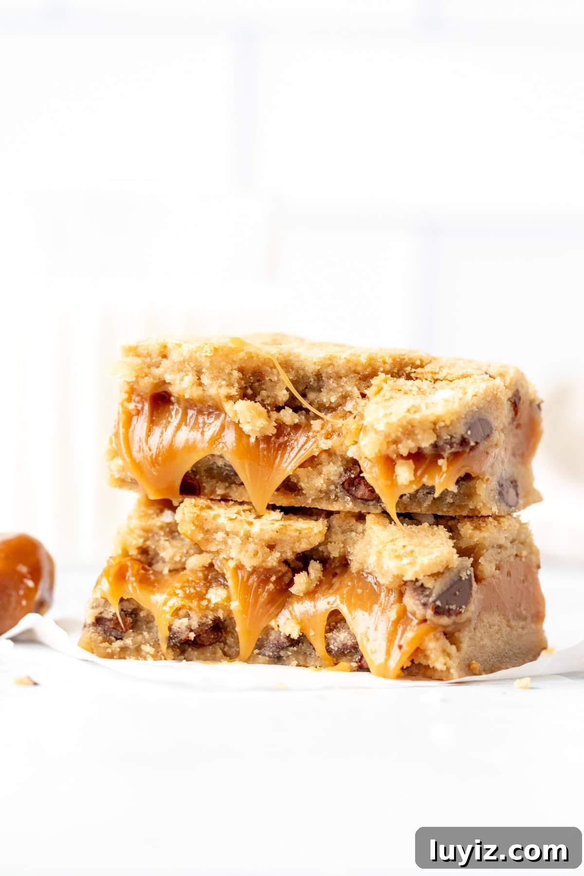 Salted Caramel Chocolate Chip Cookie Bars: Gooey & Chewy Recipe 8 Caramel chocolate chip cookie bar, broken in half with the two halves stacked on top of each other