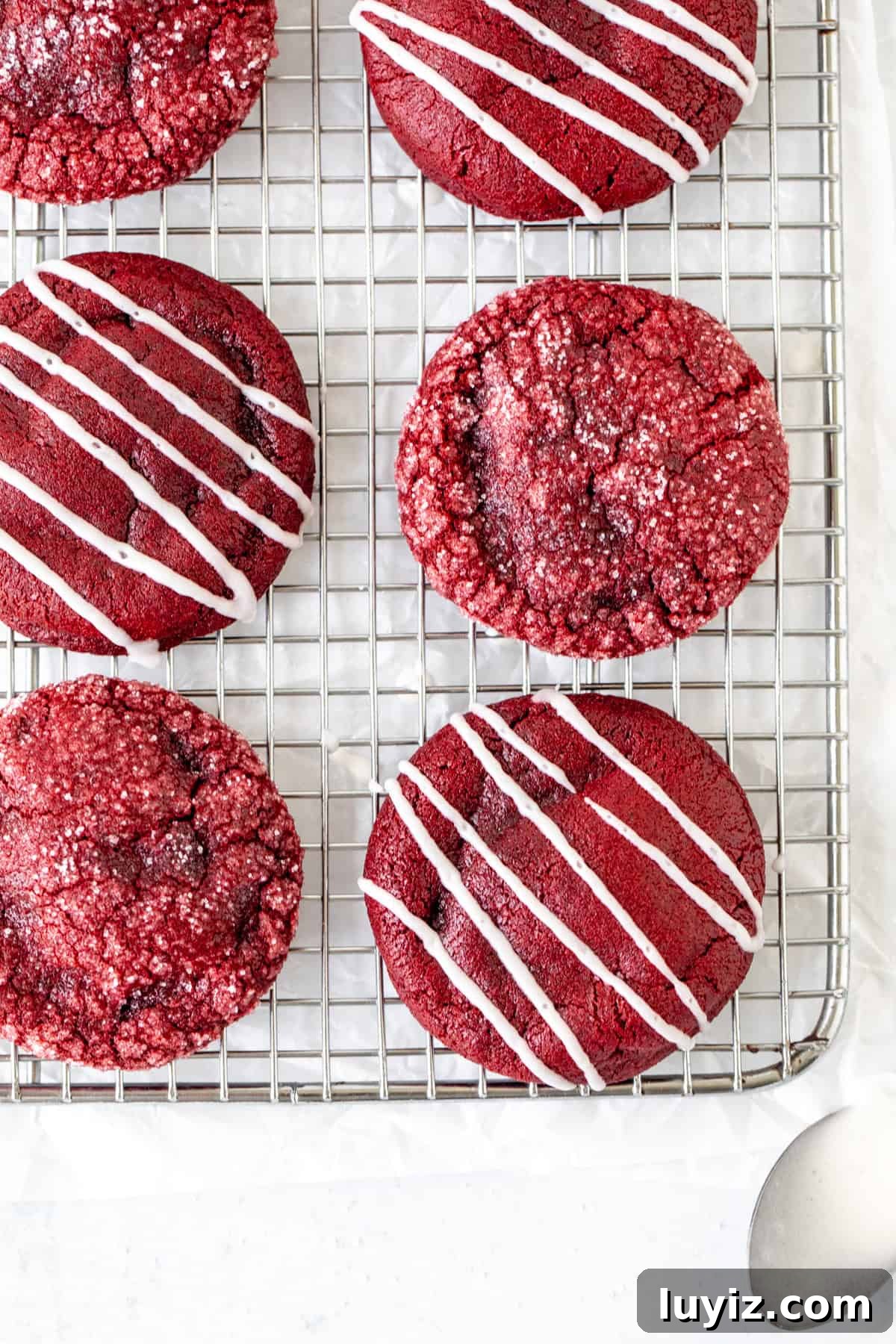 Red Velvet Cheesecake Cookies Recipe — Soft, Cream Cheese Swirl 3 Red velvet cookies on a cooling rack, some cookies drizzled with glaze and some rolled in sugar
