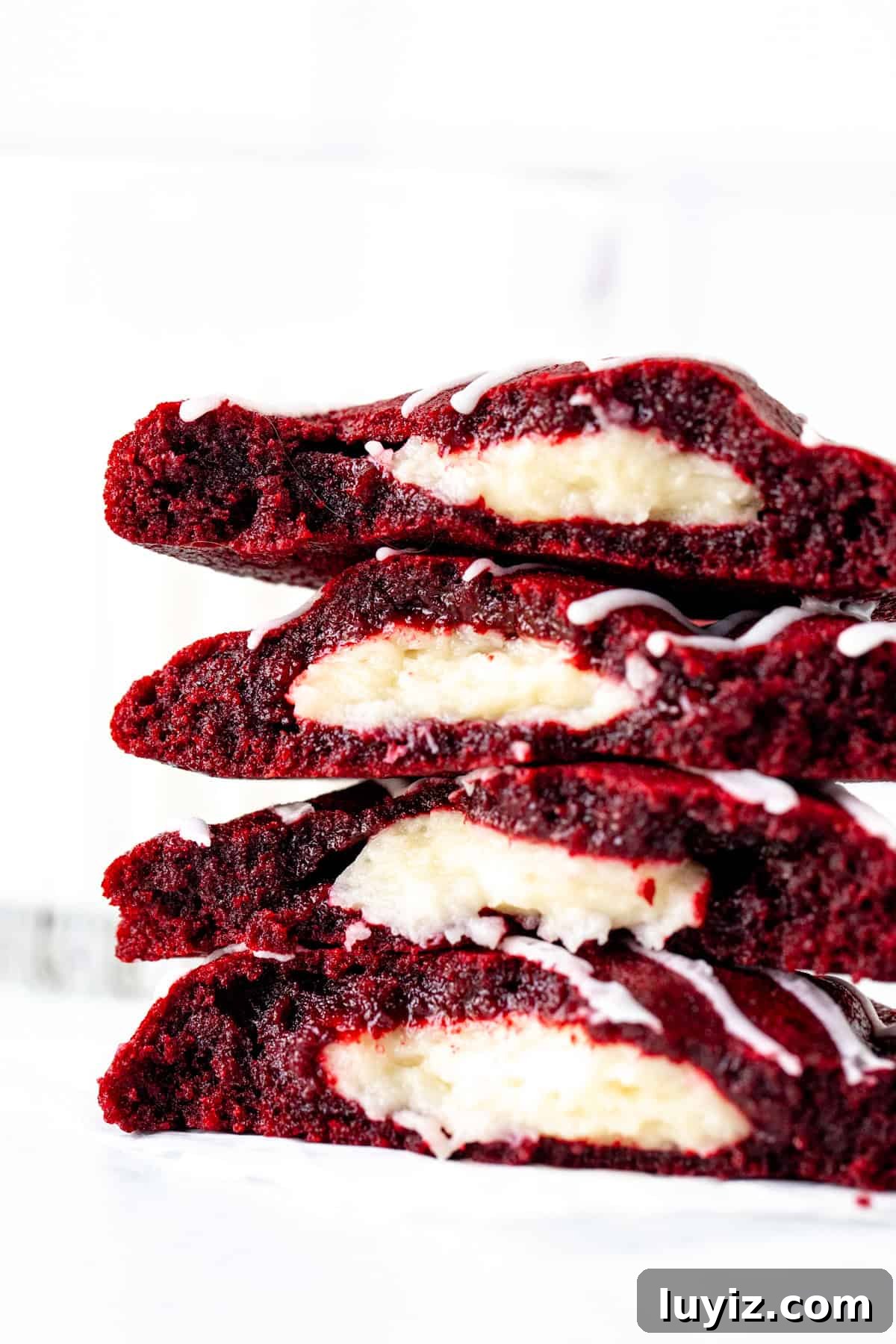 Red Velvet Cheesecake Cookies Recipe — Soft, Cream Cheese Swirl 9 cheesecake stuffed red velvet cookies, broken in half and stacked on top of each other
