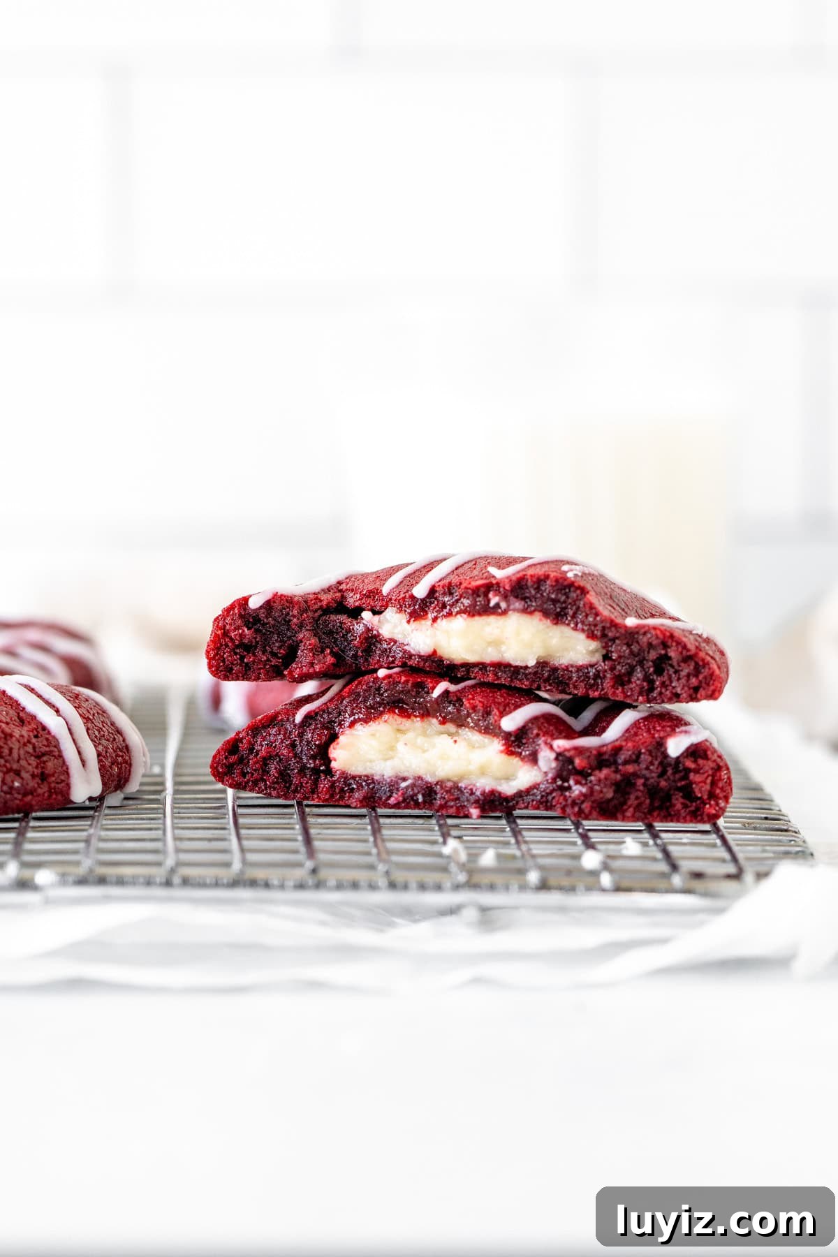 Red Velvet Cheesecake Cookies Recipe — Soft, Cream Cheese Swirl 10 Red velvet cheesecake cookie broken in half on cooling rack