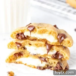Cheesecake-Stuffed Chocolate Chip Cookies — Decadent Dessert Recipe 9 Cream cheese stuffed cookies, broken in half and stacked on top of each other