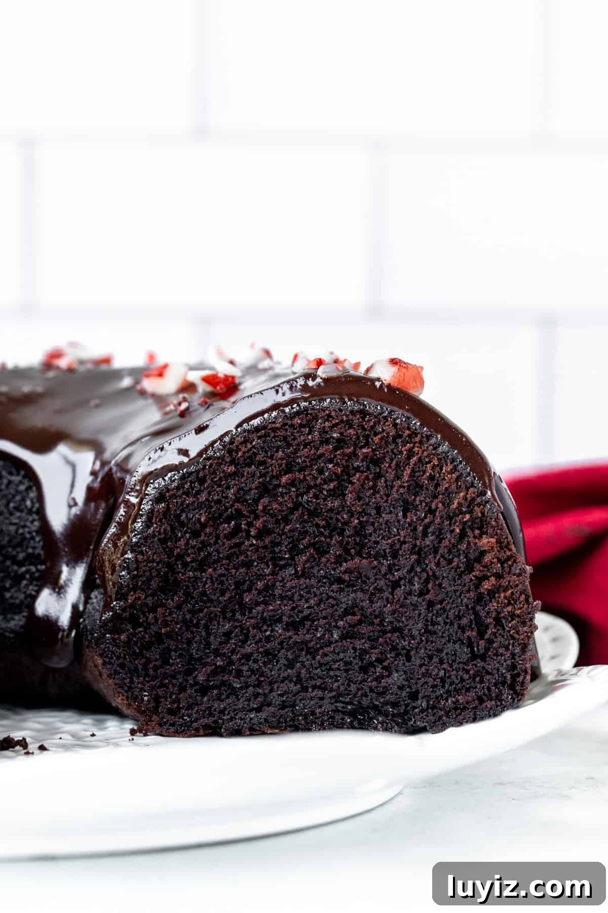Peppermint Chocolate Bundt Cake Recipe with Frosted Cocoa Glaze 7 Chocolate peppermint bundt cake on a plate, with slices cut