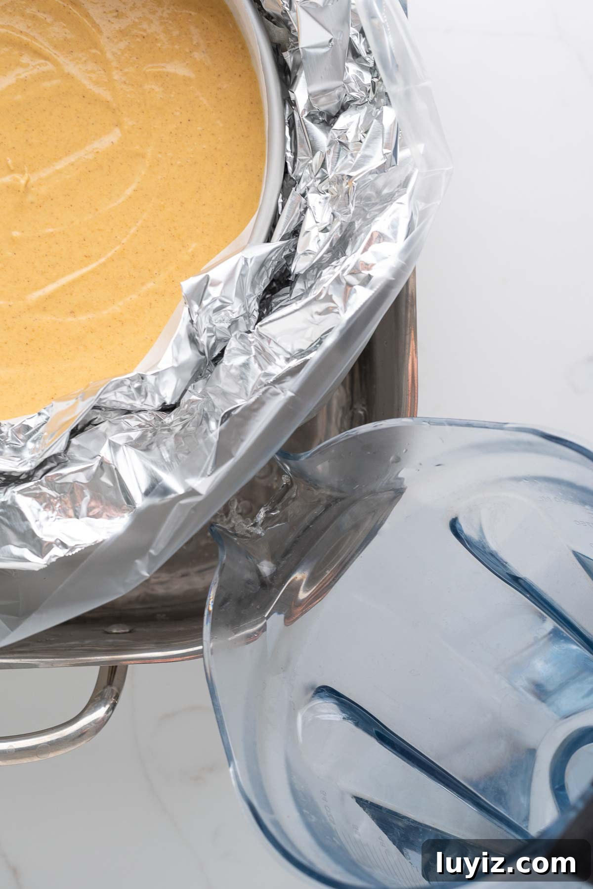 Creamy Pumpkin Cheesecake Recipe for Fall Desserts 15 Filling a roasting pan with hot water for a water bath to bake the cheesecake.