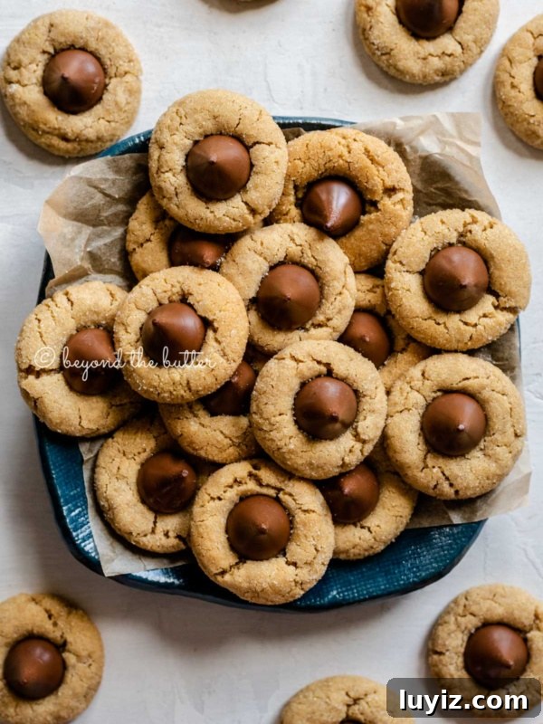 Creamy Pumpkin Cheesecake Recipe for Fall Desserts 23 Overhead image of classic peanut butter blossoms on a parchment lined blue dessert platter.