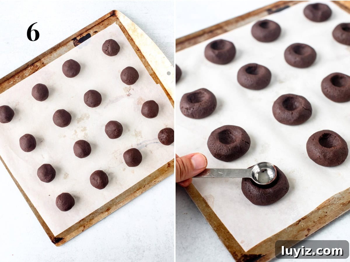 Chocolate Thumbprint Cookies with Gooey Jam Centers 6 Chocolate cookie dough balls on lined cookie sheet, and unbaked chocolate thumbprint cookies with indent in the middle.