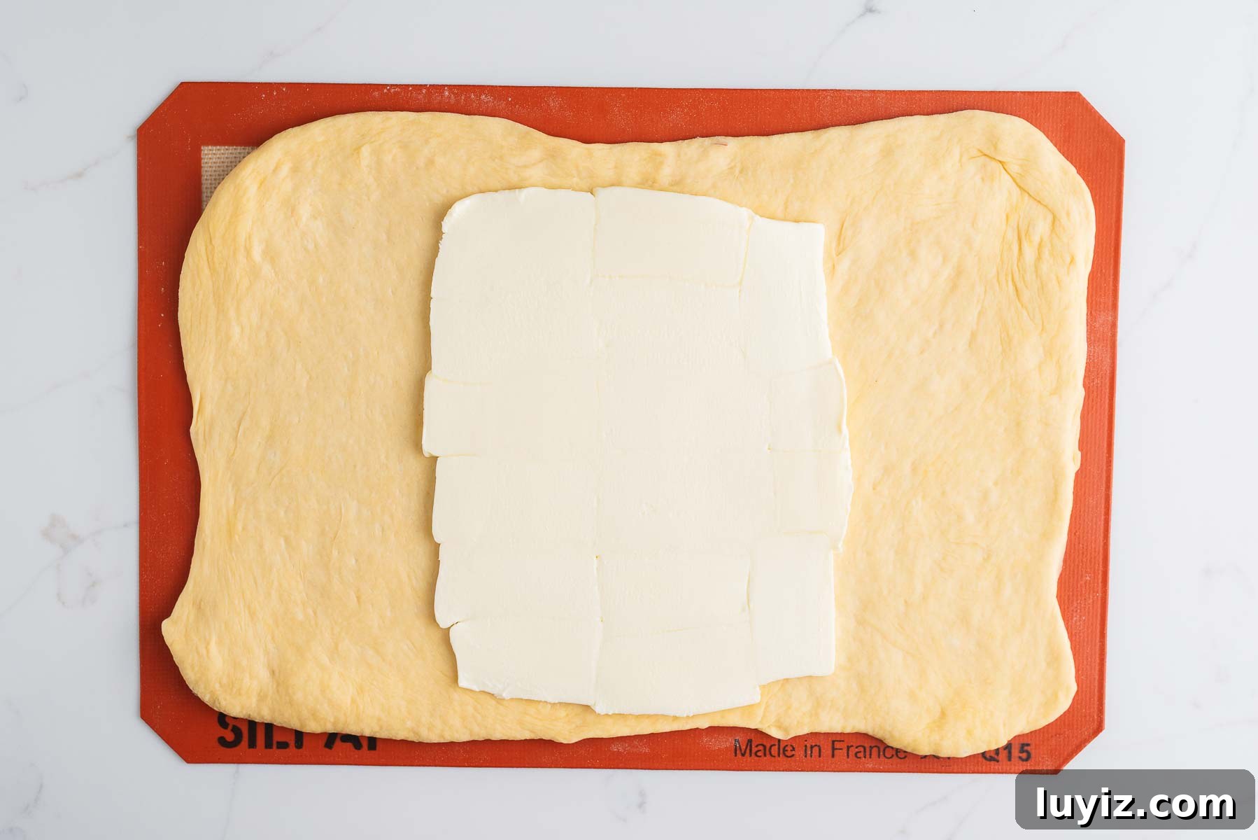 Chocolate Croissant Loaf Recipe: Flaky Chocolate Swirl Bread 10 Rolled out croissant dough into a ten inch by 14 inch rectangle with a rectangular slab of butter placed in the center third section of the dough on a silicone baking sheet.