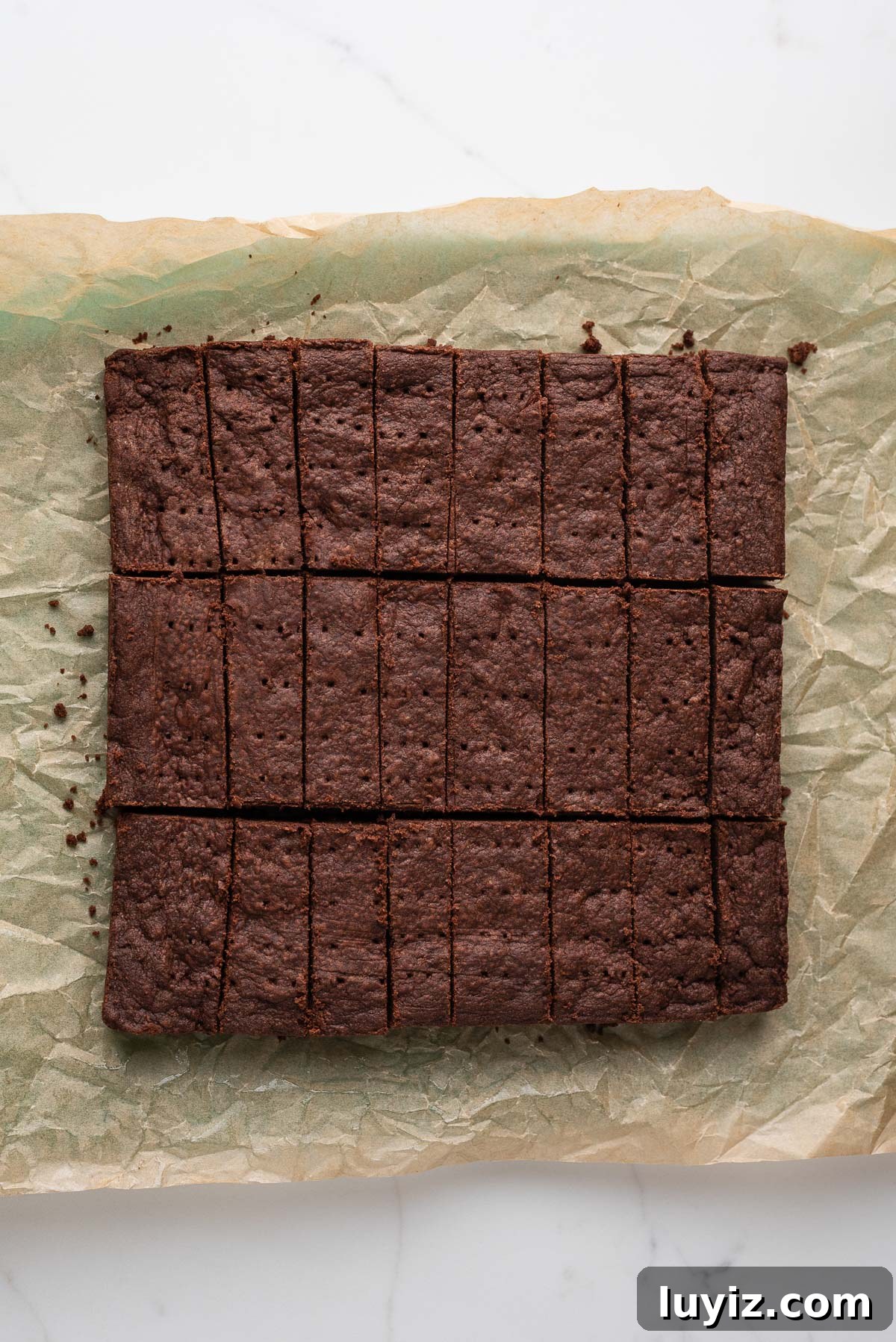 Classic Chocolate Shortbread Cookies Recipe for Homemade Treats 13 Sliced chocolate shortbread biscuits ted lasso style on a parchment paper lined cutting board and white marbled surface.