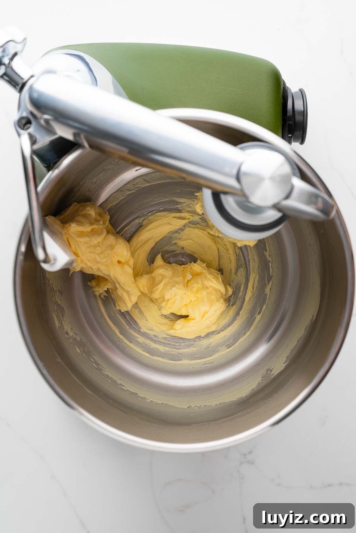 Classic Chocolate Shortbread Cookies Recipe for Homemade Treats 7 Beating unsalted butter in a forest green colored Ankarsrum Assistent Original Mixer on a white marbled surface.